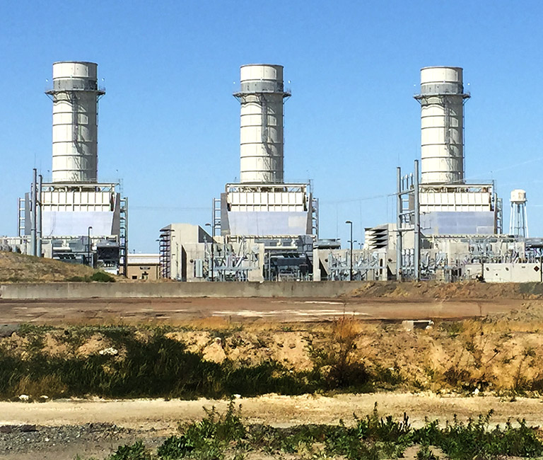 Three natural gas-powered facilities with blue skies.