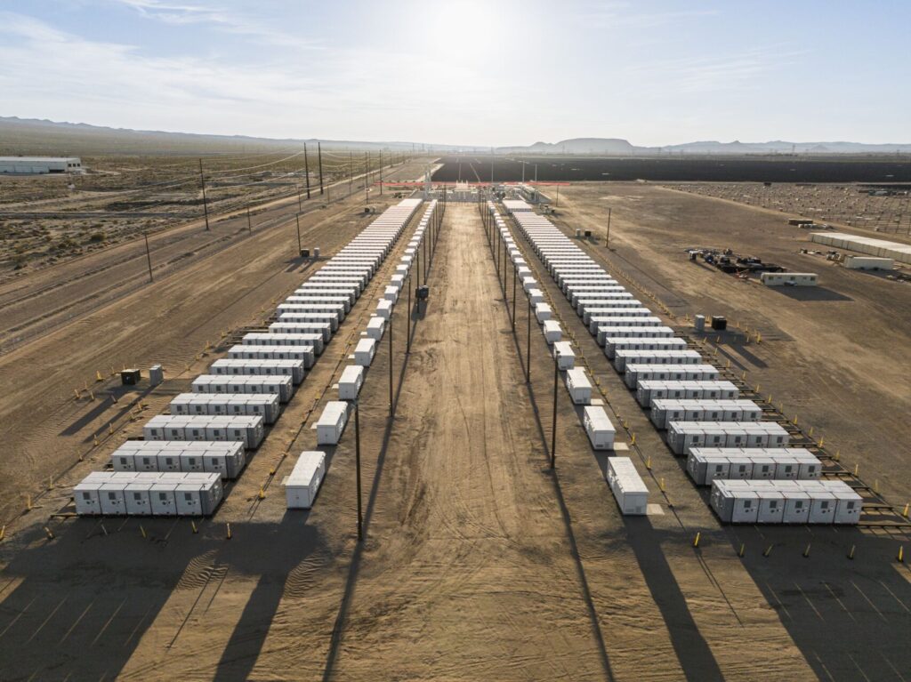 Two rows of battery storage with the sun shining.