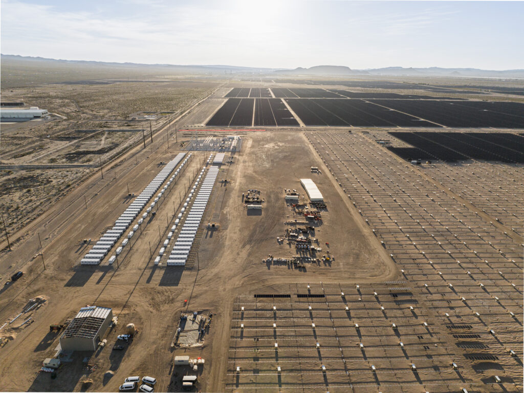 Rows of solar panels and battery storage units from aerial view